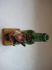 Vintage quirky fun bottle with figurine of a Scottish Bagpipe player (Angus MacFlasher) in front of the bottle