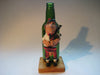 Vintage quirky fun bottle with figurine of a Scottish Bagpipe player (Angus MacFlasher) in front of the bottle