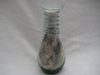 Multi coloured patterned sand in a glass bottle