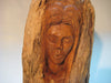 A bust (sculpture) of a woman carved out of a log