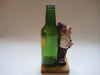 Vintage quirky fun bottle with figurine of a Scottish Bagpipe player (Angus MacFlasher) in front of the bottle