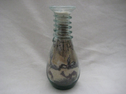 Multi coloured patterned sand in a glass bottle