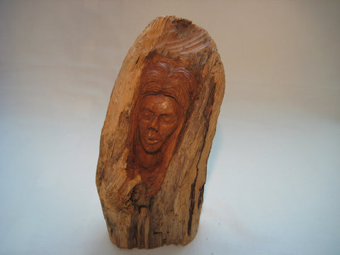 A bust (sculpture) of a woman carved out of a log